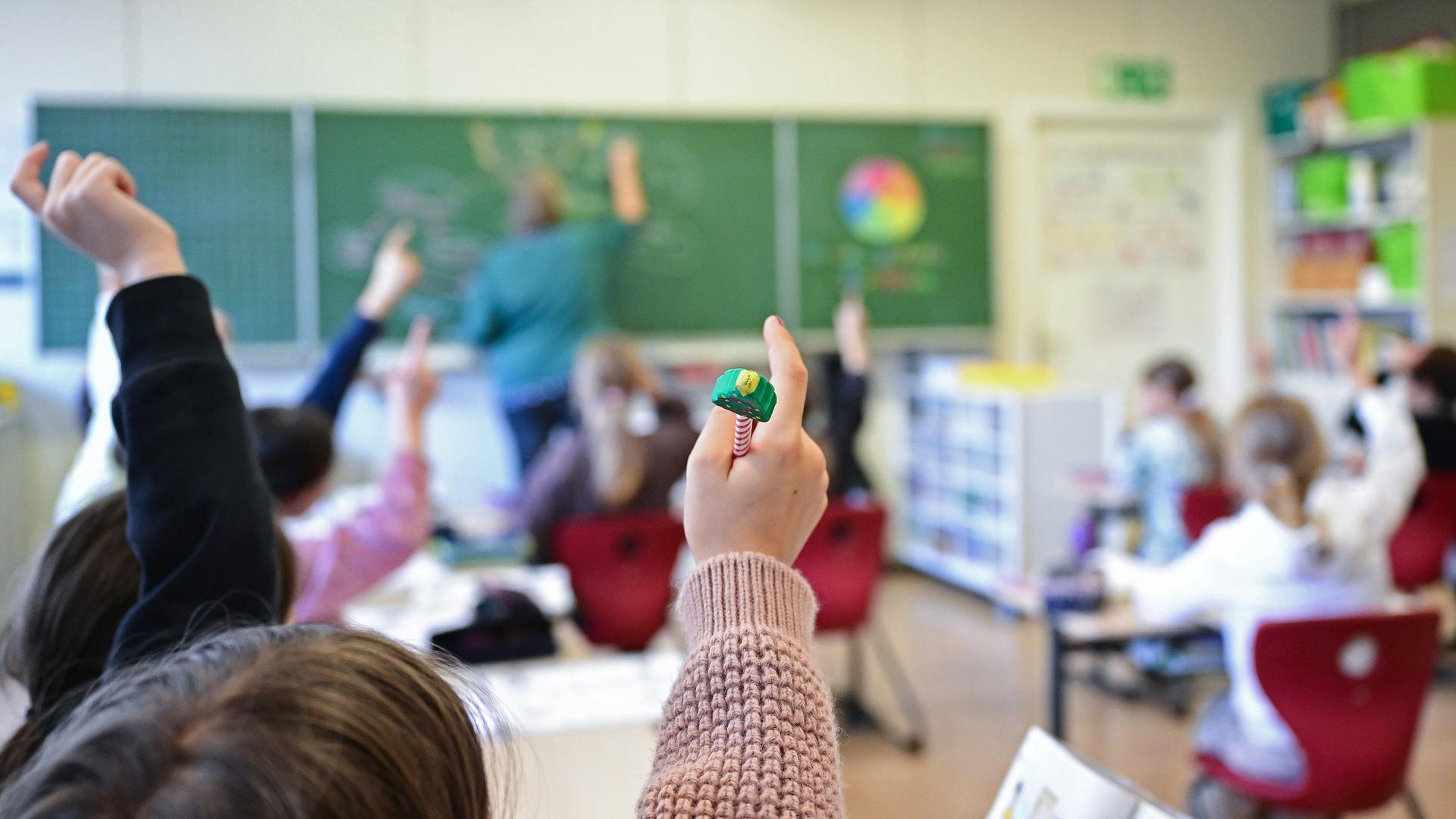 Schüler melden sich in einer vierten Klasse in einer Grundschule in Stuttgart