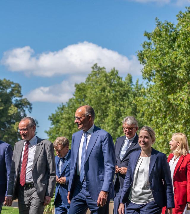Bundeskanzler Merz mit seinem Kabinett auf dem Weg zu einem Gruppenfoto während der Klausurtagung.