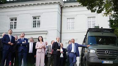 25.08.2026, Brandenburg, Neuhardenberg: Bundeskanzler Friedrich Merz (r, CDU) schaut sich bei der Klausurtagung der Bundesregierung im Schloss Neuhardenberg die Tytan-Drohne Hyperion zusammen mit seinen Kabinettskollegen an.