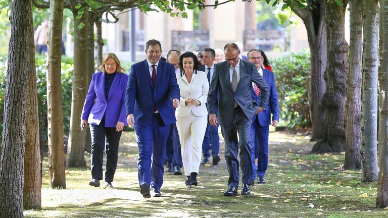 Kabinettsklausur: Bundeskanzler Friedrich Merz (CDU) laeuft mit seinen Ministern durch den Park, mit im Bild unter anderem Bundesministerin fuer Arbeit und Soziales Baerbel Bas (SPD), Bundesminister der Finanzen Lars Klingbeil (SPD), Bundesministerin fuer Forschung, Technologie und Raumfahrt Dorothee Baer (CSU)