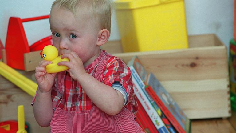 Kleinkind nimmt Spielzeug in den Mund, Archivbild