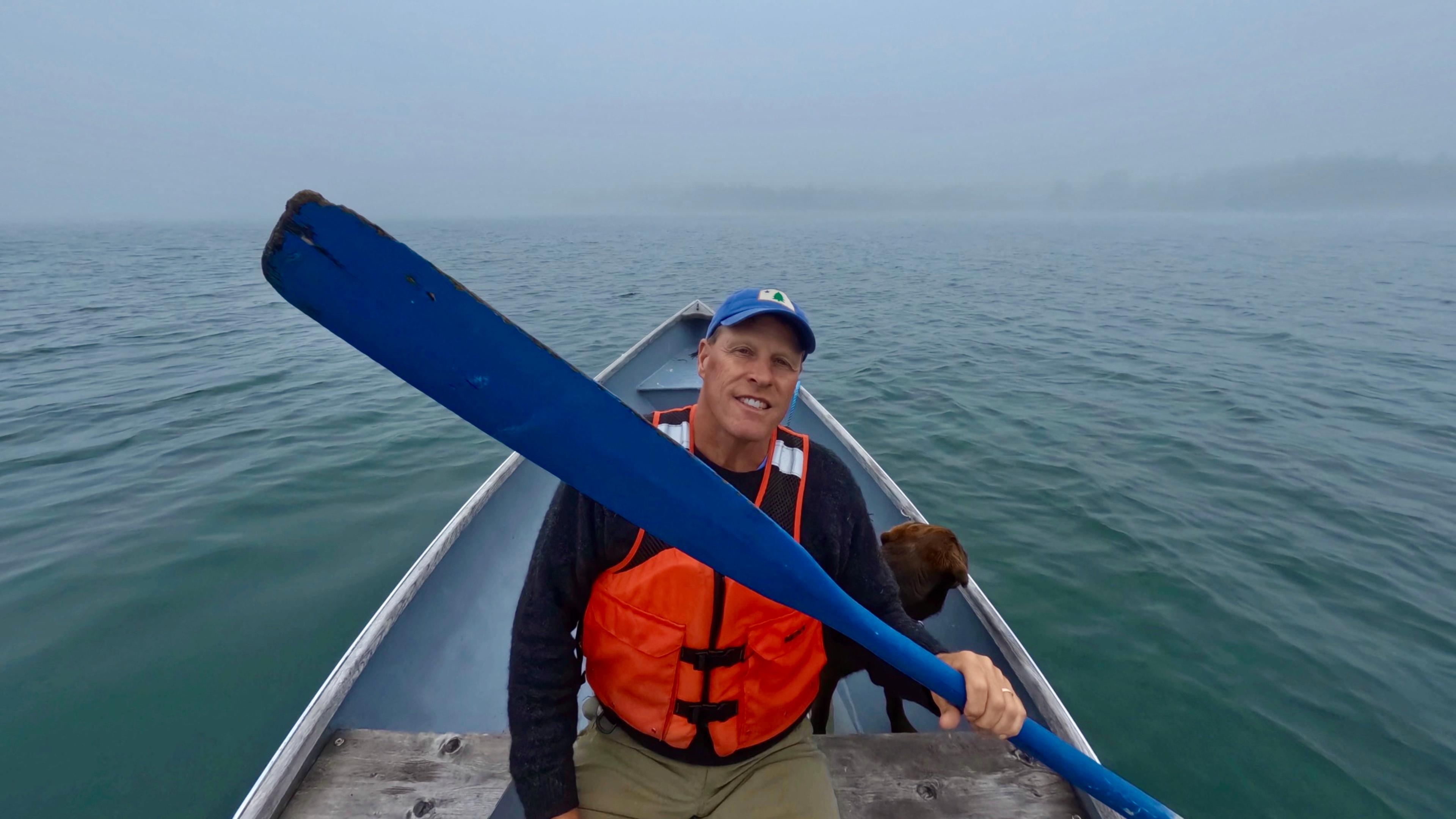 Tim Sheehan sitzt mit einem Paddel in der Hand in einem kleine Boot.