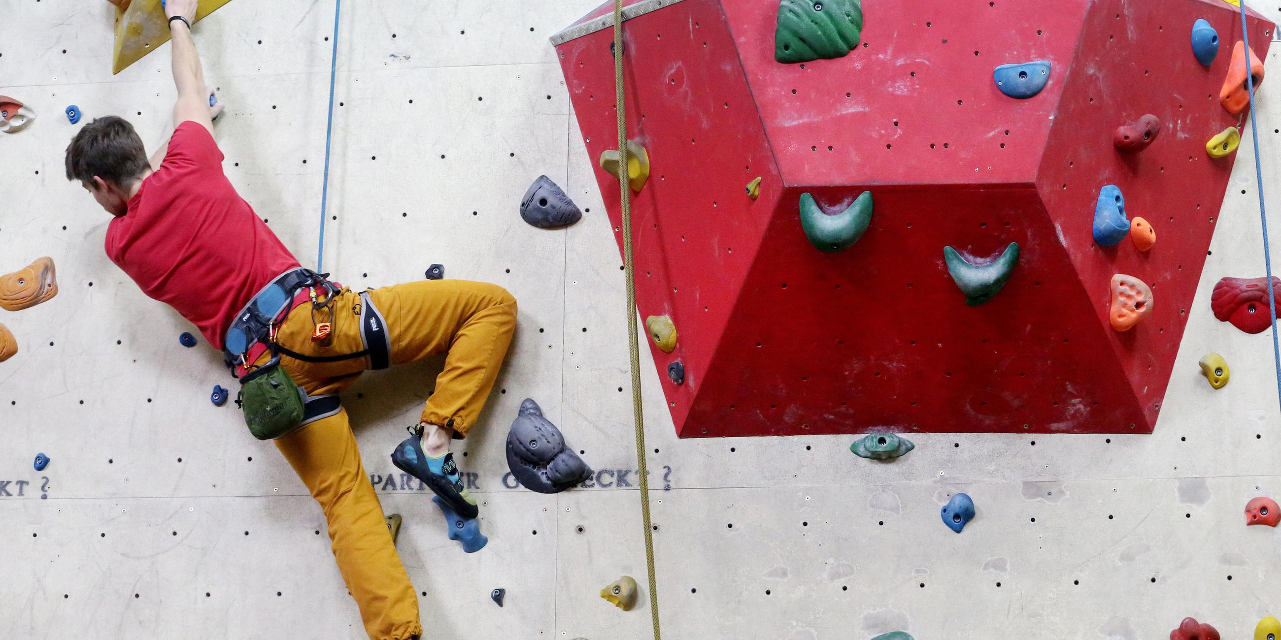 Bolderer an einer Kletterwand