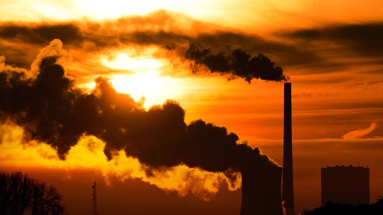 Die aufgehende Sonne taucht am 27.10.2014 den Himmel hinter dem Kohlekraftwerk Mehrum in Hohenhameln im Landkreis Peine (Niedersachsen) in warmes Licht. 