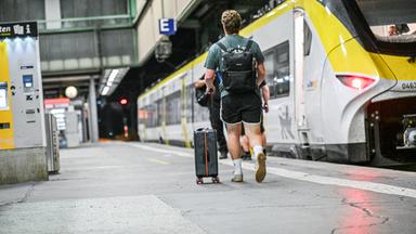 Ein Fahrgast geht auf dem Bahnsteig entlang eines Zuges im Stuttgarter Bahnhof.