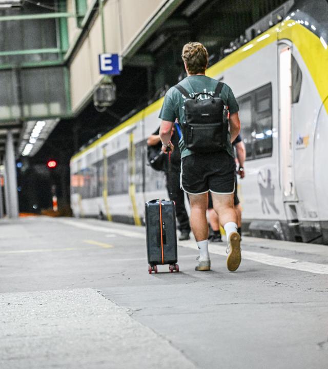 Ein Fahrgast geht auf dem Bahnsteig entlang eines Zuges im Stuttgarter Bahnhof.