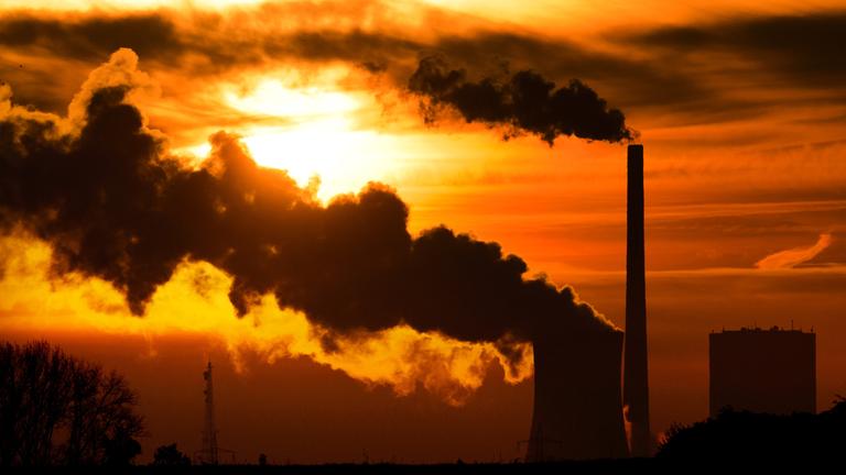 Die aufgehende Sonne taucht am 27.10.2014 den Himmel hinter dem Kohlekraftwerk Mehrum in Hohenhameln im Landkreis Peine (Niedersachsen) in warmes Licht.