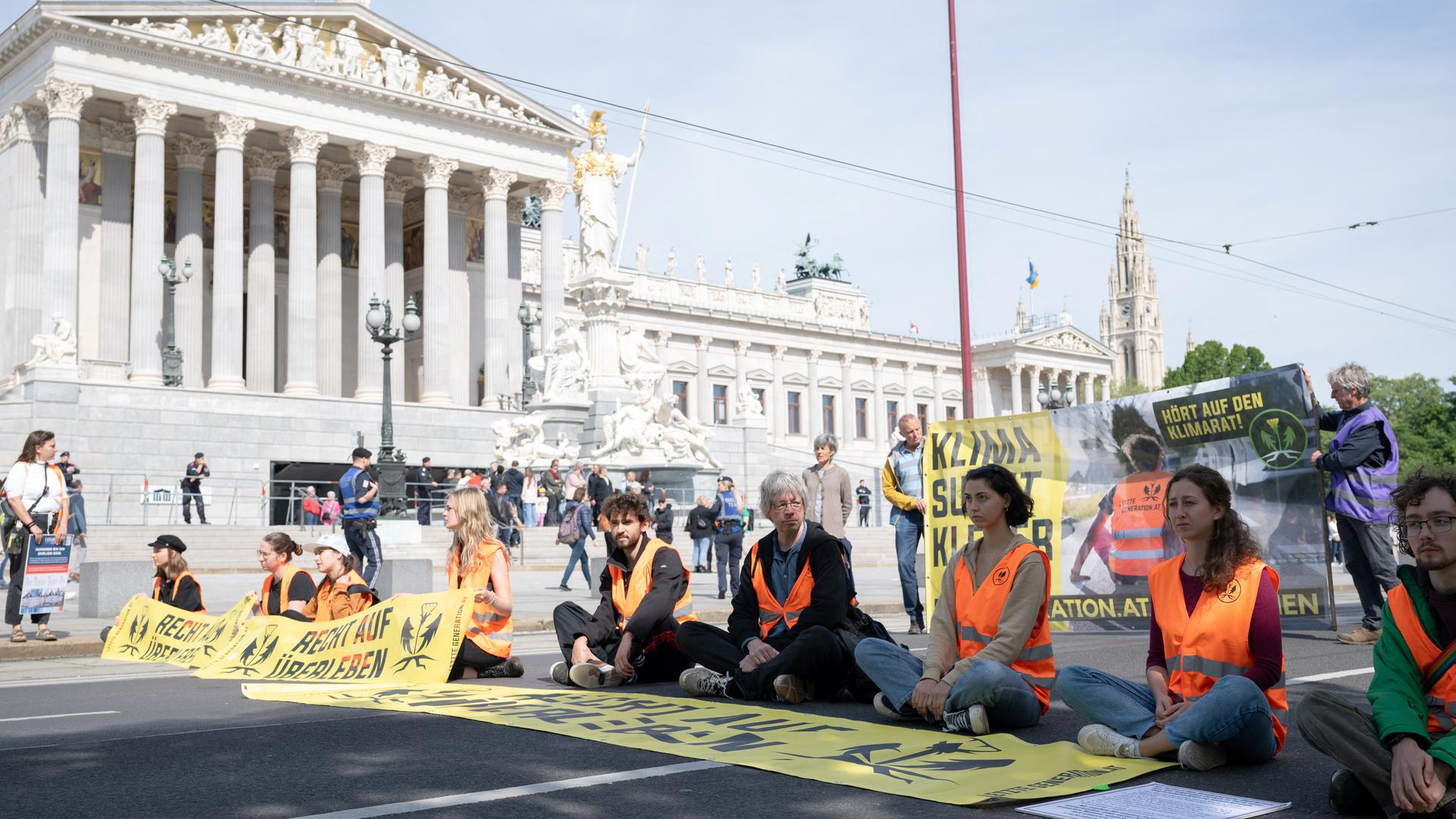 Klimaaktivisten blockieren die Straße vor dem österreichischen Parlament in Wien