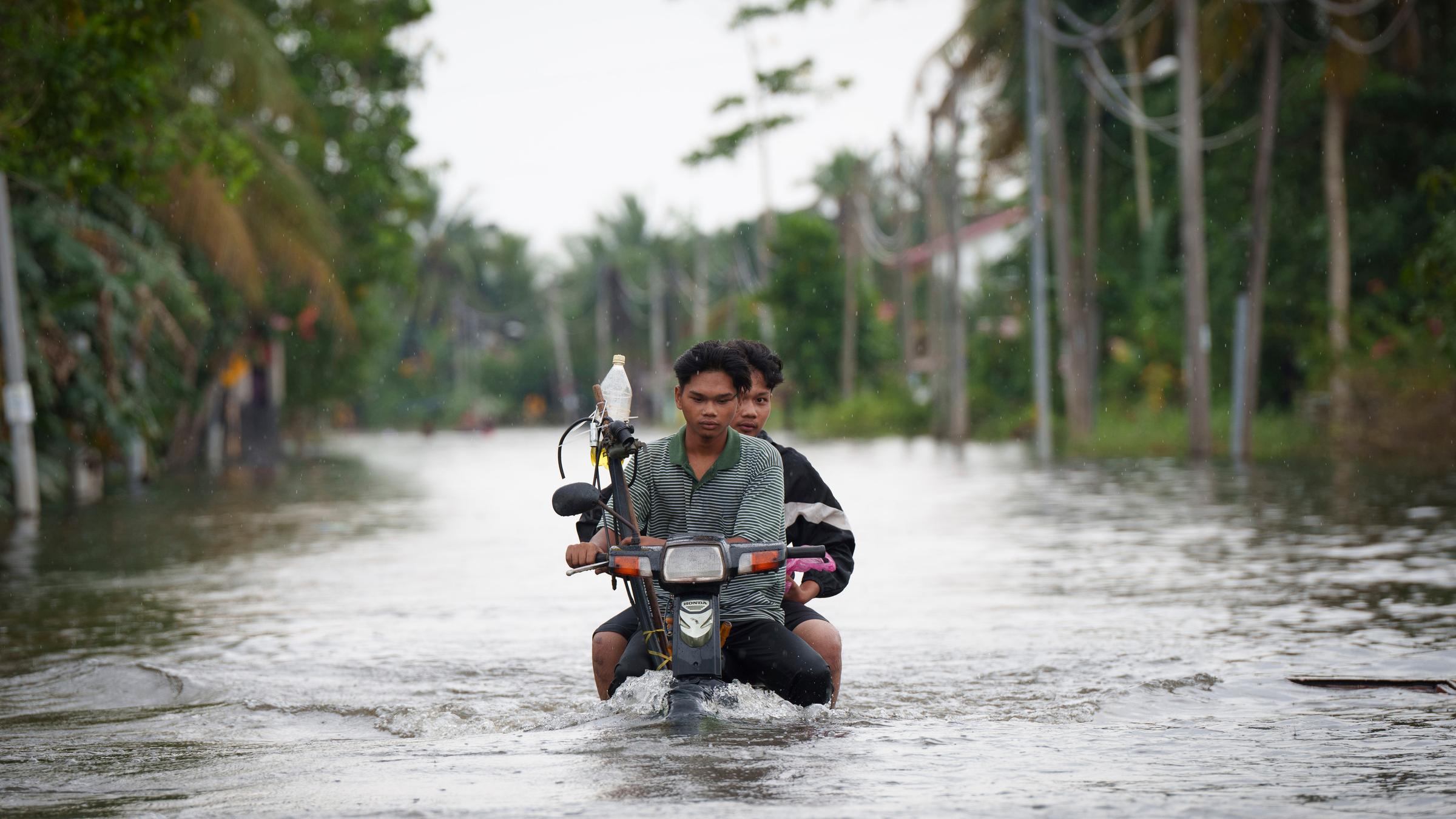 Anwohner auf Mofa nach Hochwasser in Malaysia