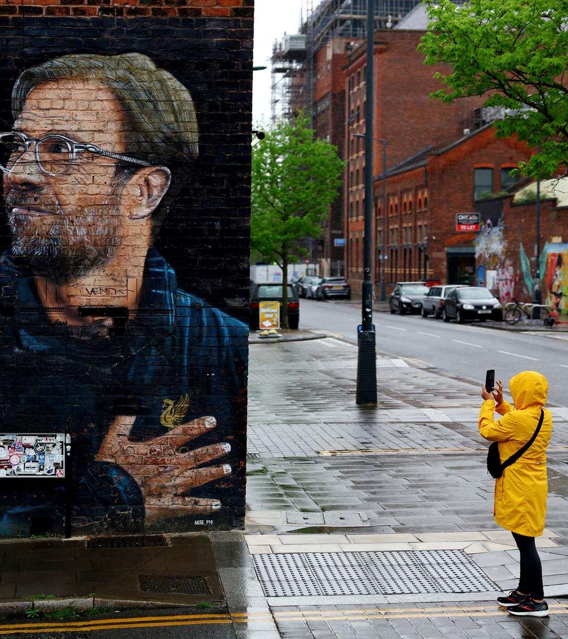 Eine Person fotografiert eine Wandgrafik von Jürgen Klopp