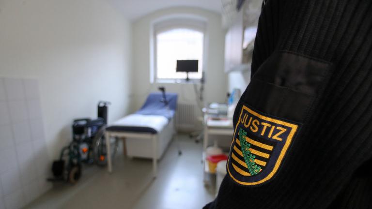 Eine Justizvollzugsbeamtin steht in einem Behandlungsraum für ältere Häftlinge im Seniorentrakt einer JVA.