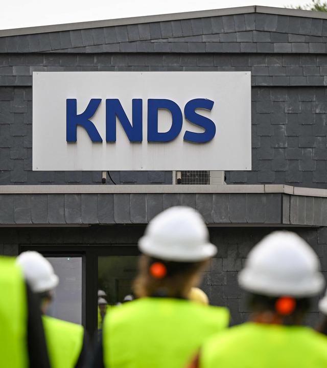 Besucher gehen während des Cleantech Future Festivals in Remscheid an einem Schild der KNDS Deutschland Tracks GmbH vorbei.