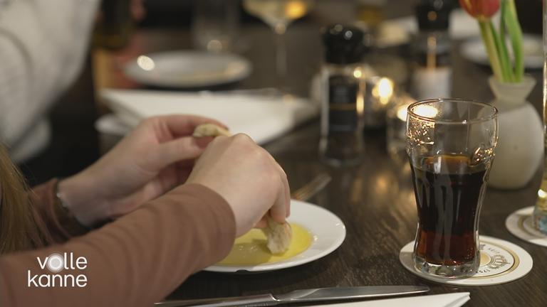 Tisch und Hände einer Person beim Essen