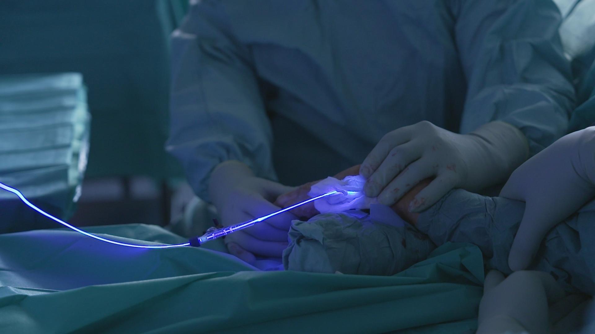 Bei einer Operation wird ein Knochenimplantat aus Kunststoff mithilfe von Blaulicht angehärtet.