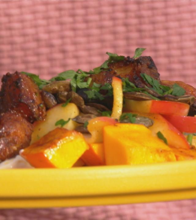 Knuspriger Schweinebauch mit BBQ-Kürbis auf einem gelben Teller serviert.