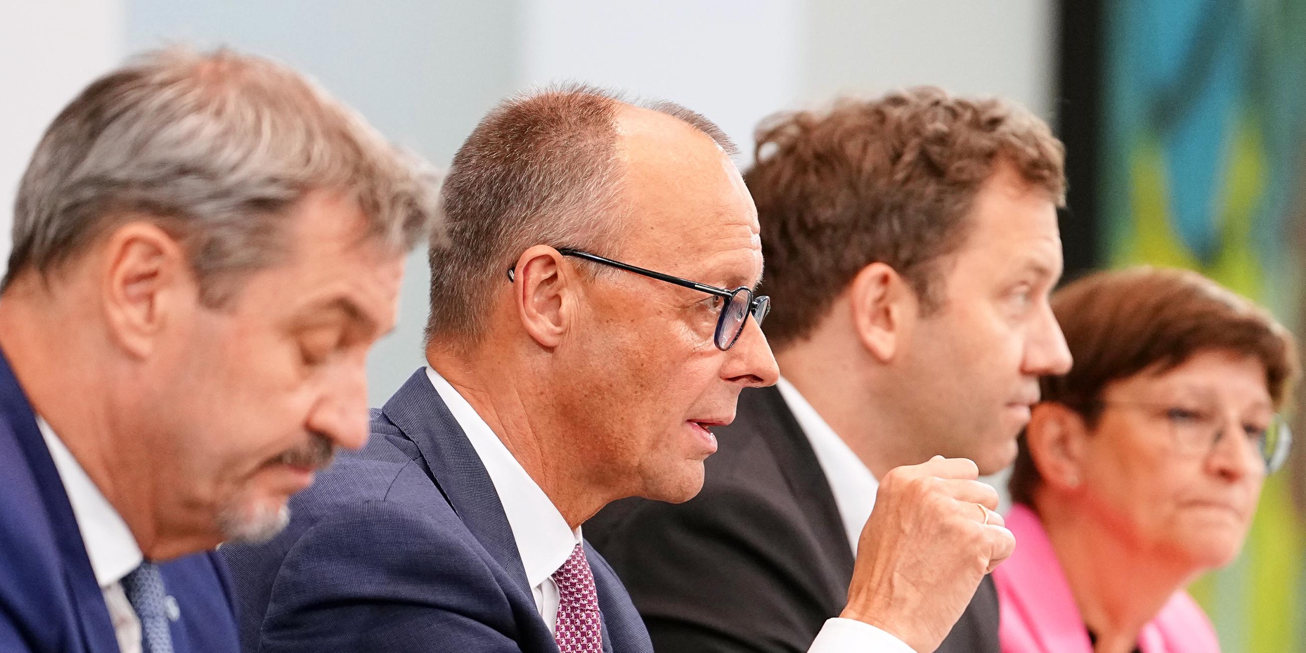 Bundeskanzler Friedrich Merz (CDU, 2.v.l) spricht neben Markus Söder (l-r), Ministerpräsident von Bayern und CSU-Vorsitzender, Lars Klingbeil, Bundesfinanzminister und SPD-Parteivorsitzender, und Saskia Esken, SPD-Parteivorsitzende.