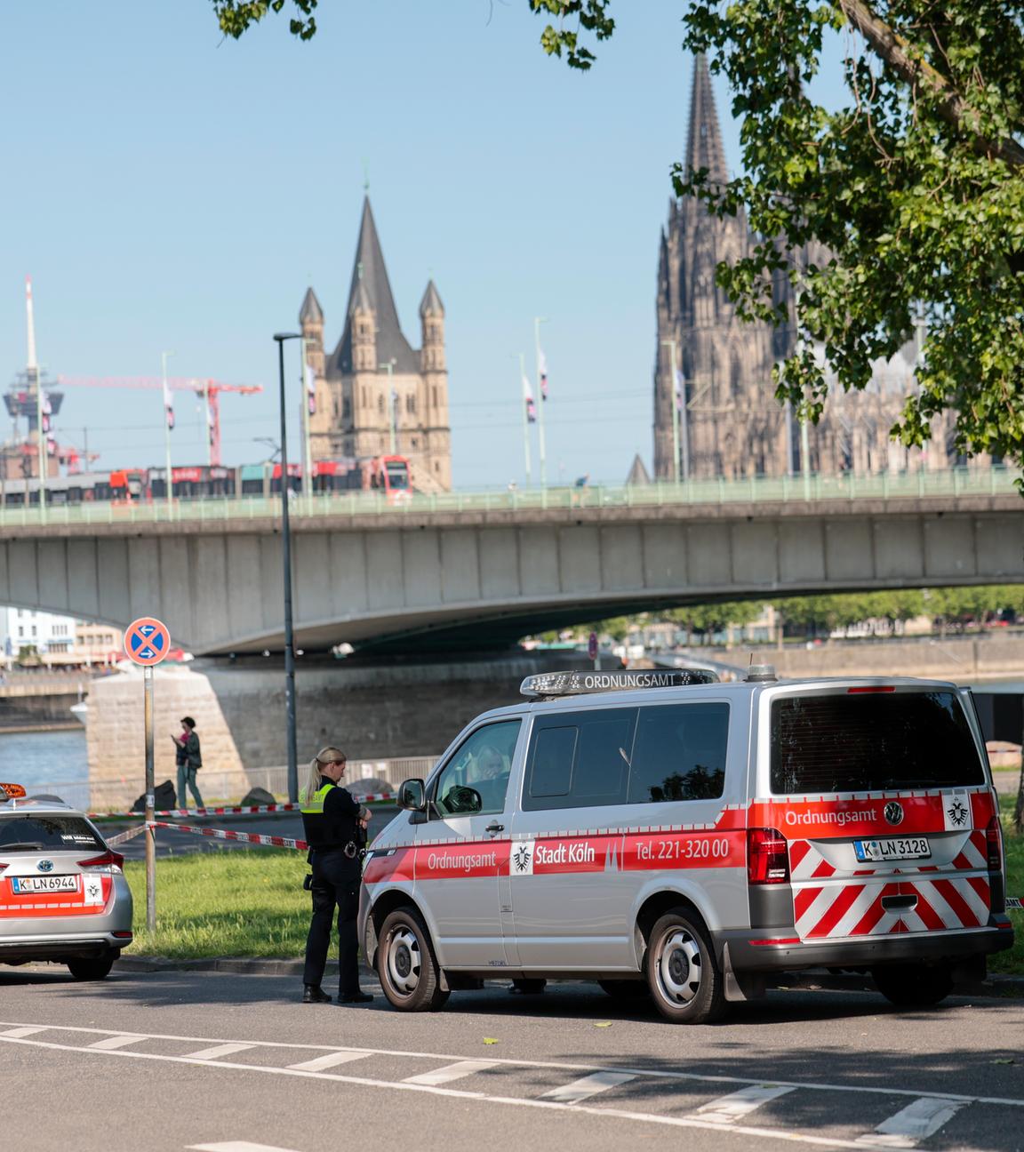 03.06.2025, Nordrhein-Westfalen, Köln: Am Deutzer Ufer stehen Einsatzkräfte des Ordnungsamtes im Bereich der gefundenen drei Bombenblindgänger aus dem Zweiten Weltkrieg zur Bewachung.