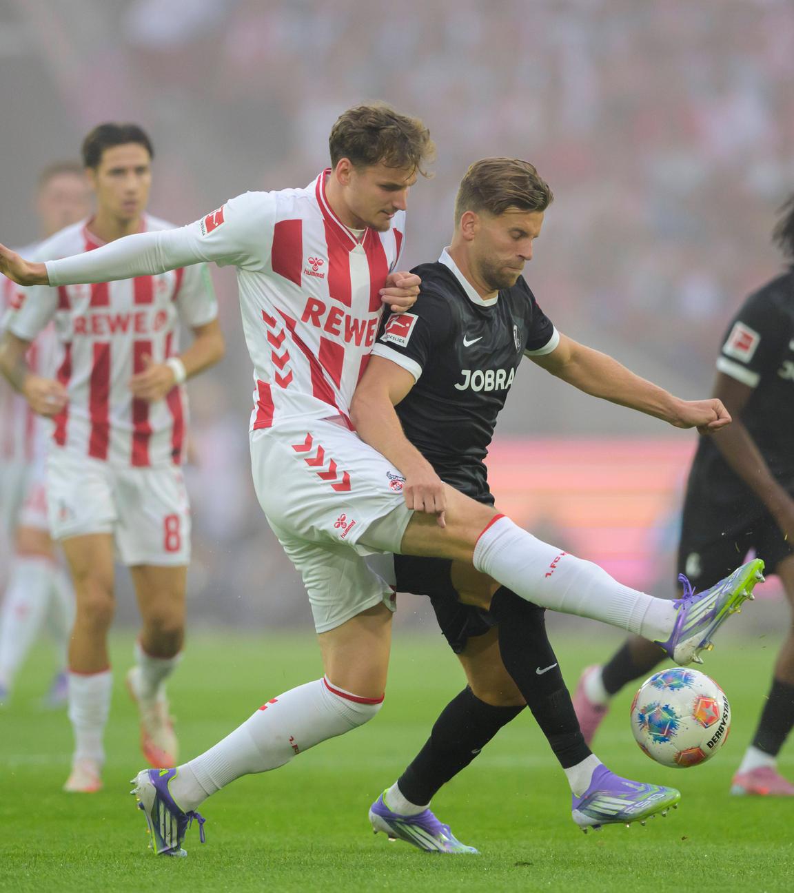 Rav van den Berg (1. FC Köln) und Lucas Höler (SC Freiburg) kämpfen.