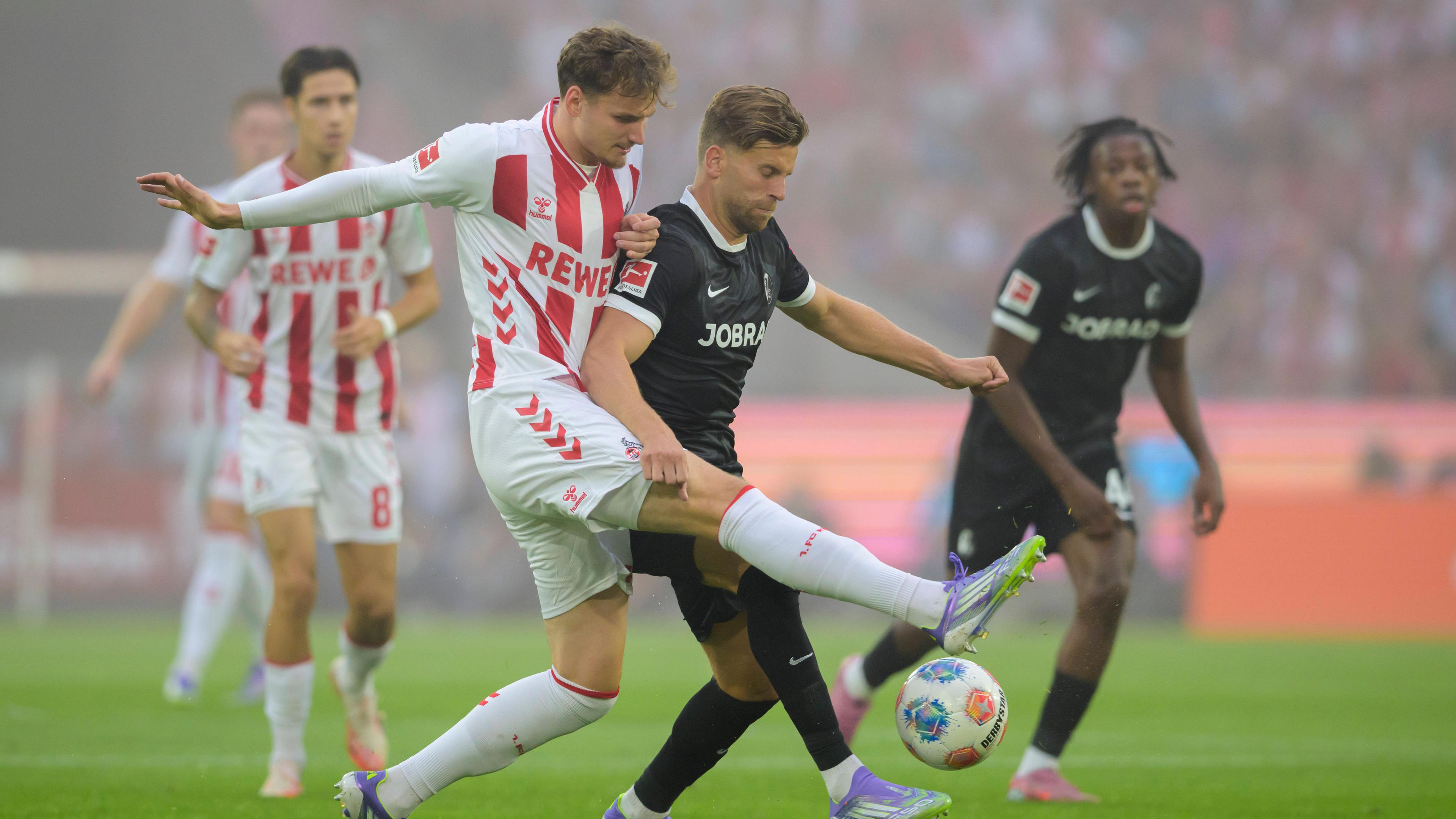 Rav van den Berg (1. FC Köln) und Lucas Höler (SC Freiburg) kämpfen.