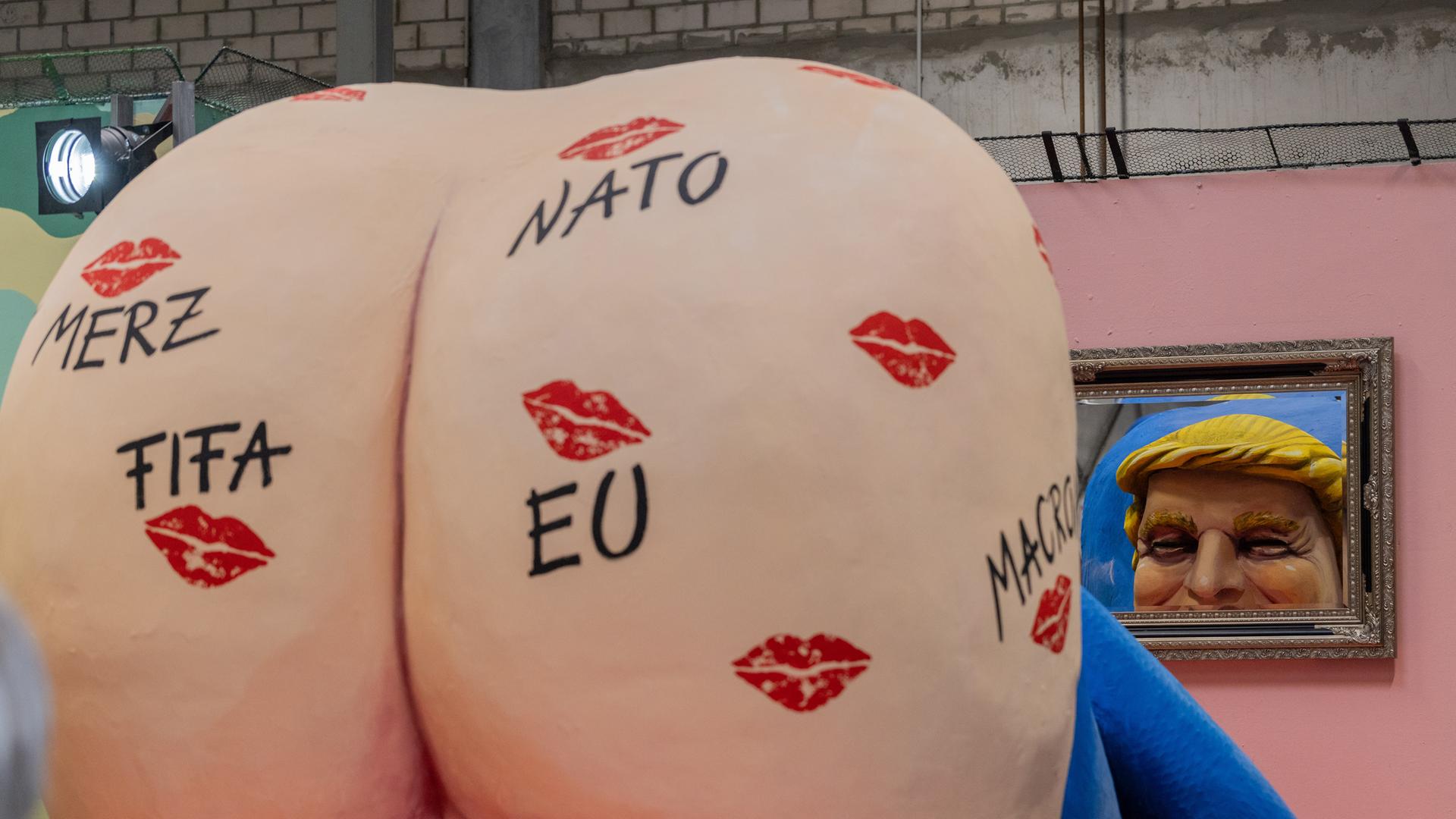 Ein Motivwagen für den Kölner Rosenmontagszug, der US-Präsident Trump mit nacktem Hintern zeigt, wird beim Richtfest in der Wagenbauhalle präsentiert.