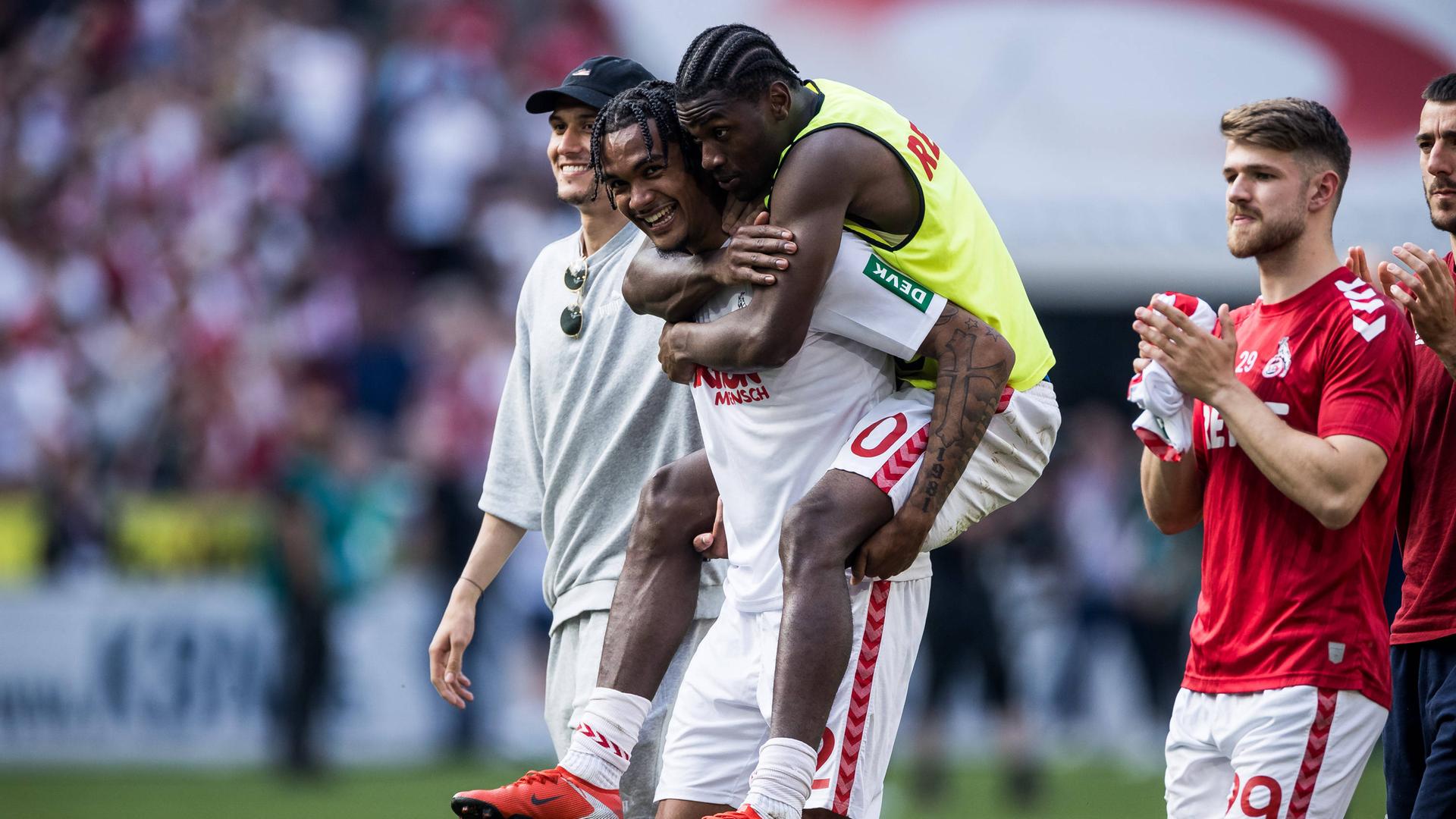 Faride Alidou springt Damion Downs auf den Rücken nach dem Sieg gegen Union Berlin.