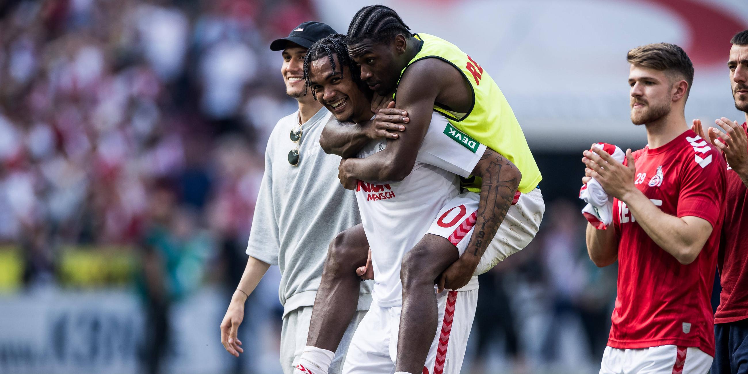 Faride Alidou springt Damion Downs auf den Rücken nach dem Sieg gegen Union Berlin.