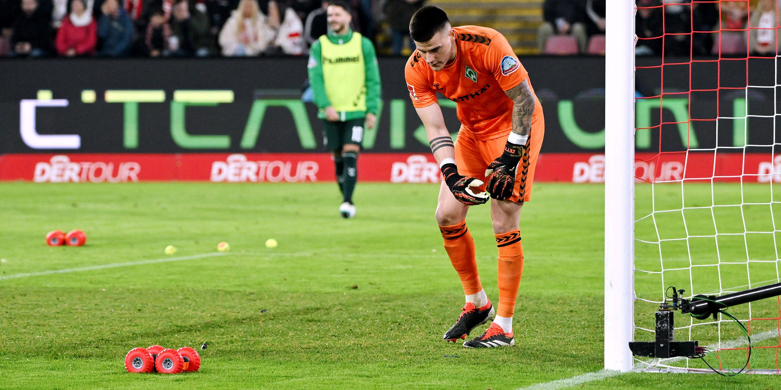 Torwart Michael Zetterer (Werder Bremen) beim Protest der Fans mit einem ferngesteuerten Auto und Tennisbällen.