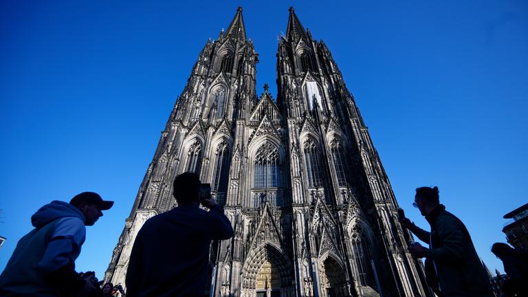 Touristen fotografieren den Kölner Dom, aufgenommen am 05.03.2026