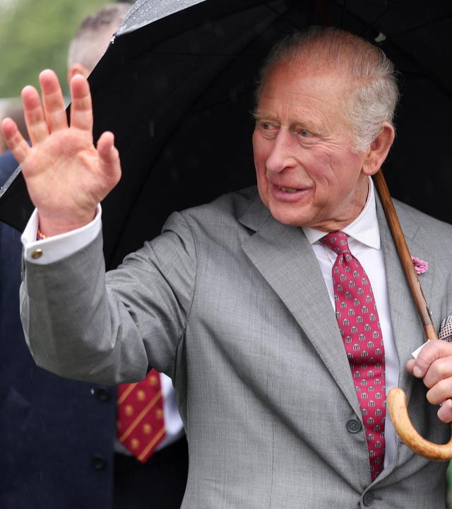 König Charles III. winkt den Bürgern während eines Besuchs im The CARE Hub zu.