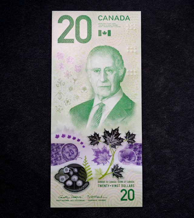 Auf dem Bild zu sehen: Eine neue kanadische 20-Dollar-Banknote liegt auf einem dunklen Hintergrund. Im Mittelpunkt der Banknote befindet sich ein Porträt von König Charles III.