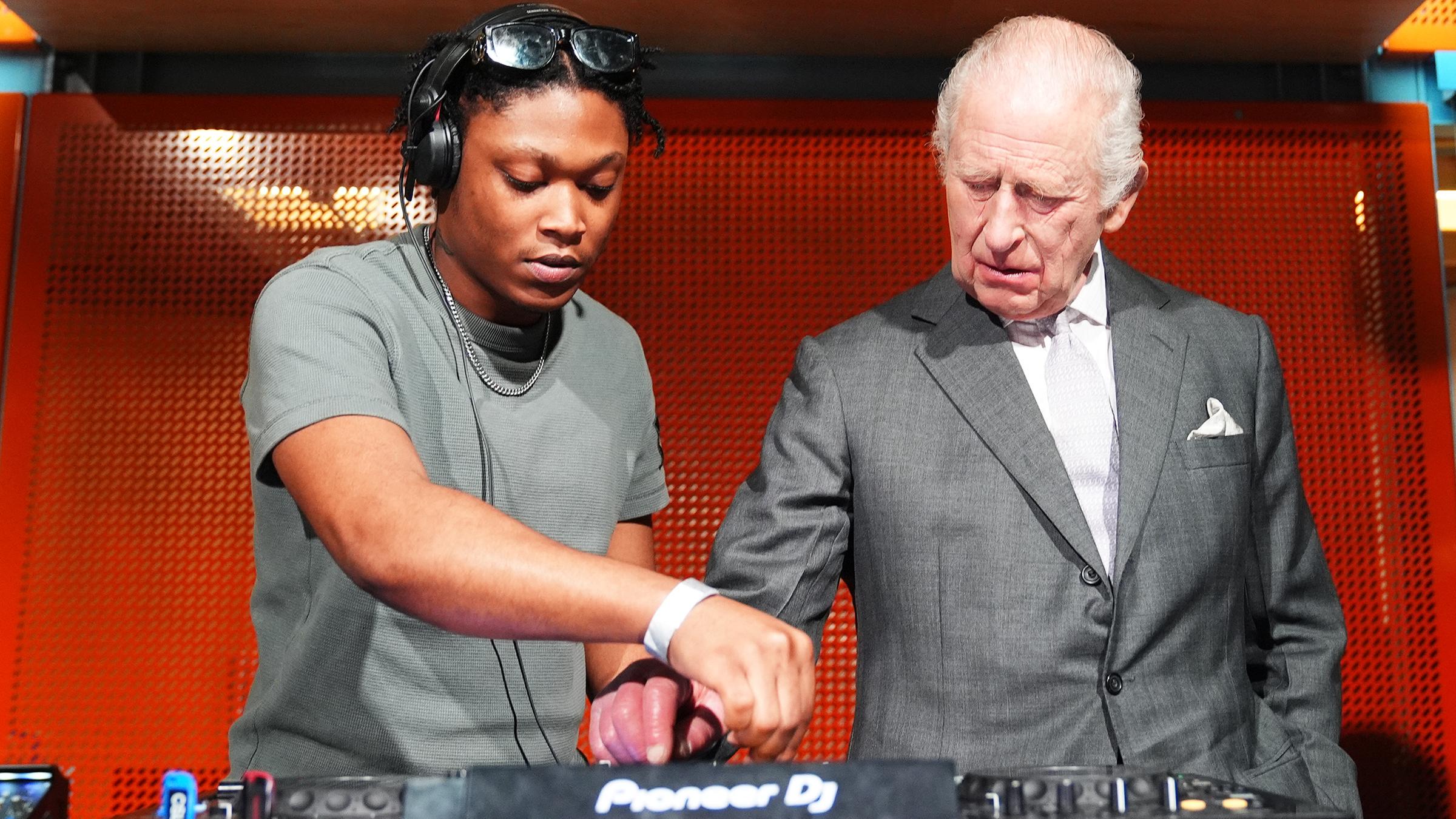 König Charles III. versucht sich in einem Kulturzentrum in Manchester als DJ.