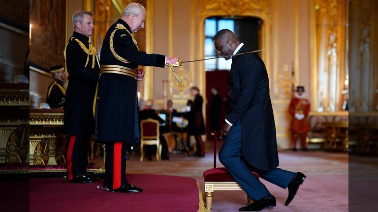 König Charles (rechts) schlägt den Schauspieler Idris Elba mit einem Schwert zum Ritter.