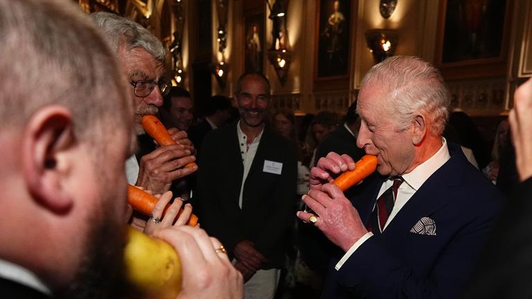 König Charles III. spielt auf der Karotten-Flöte