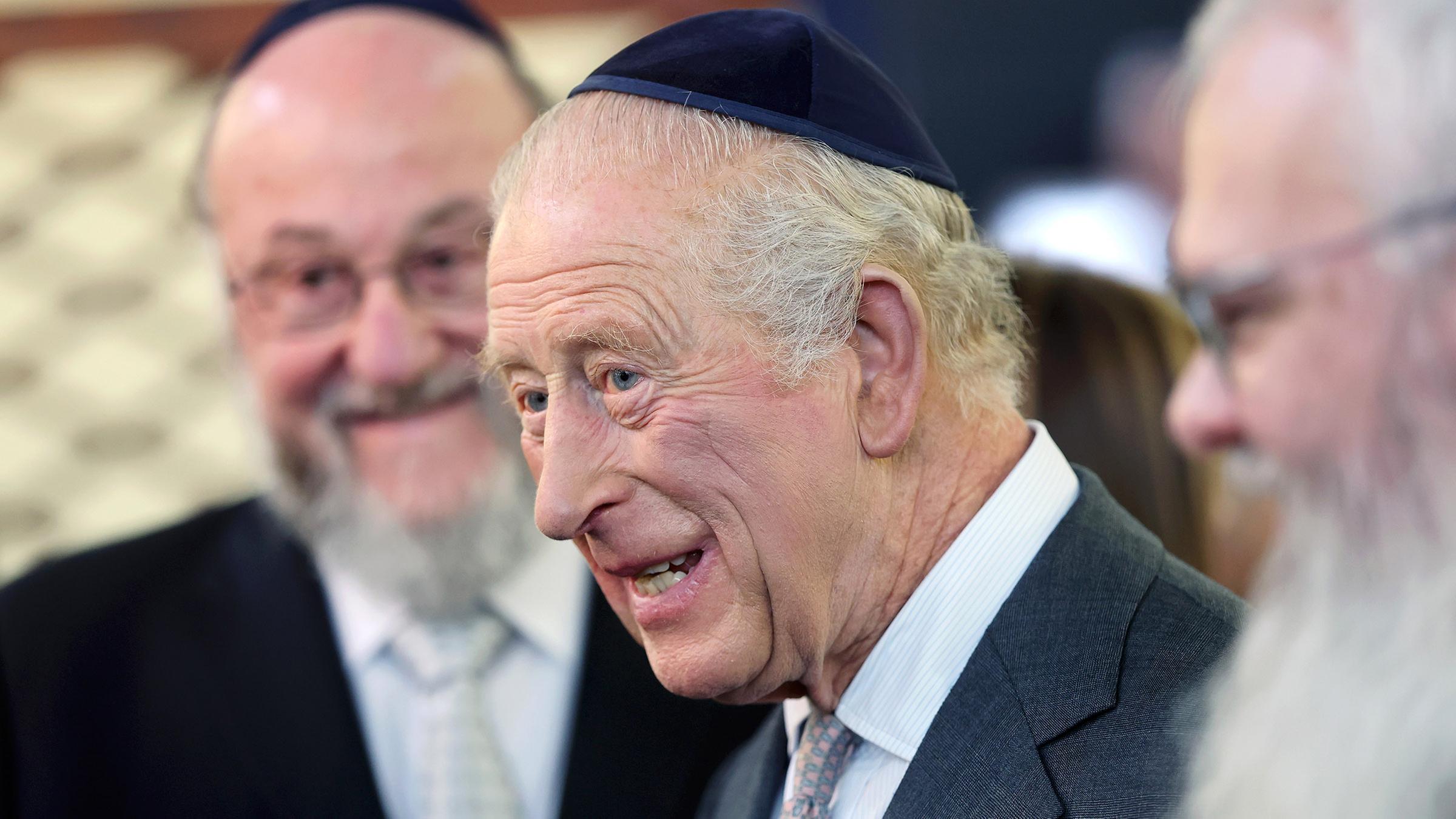 König Charles bei dem Besuch einer Synagoge, er trägt eine Kippa auf dem Kopf.
