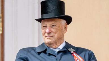 Auf dem Bild ist König Harald zu sehen. Er trägt einen schwarzen Zylinder und einen dunkelblauen Mantel mit einer rot-weiß-blauen Schleife.