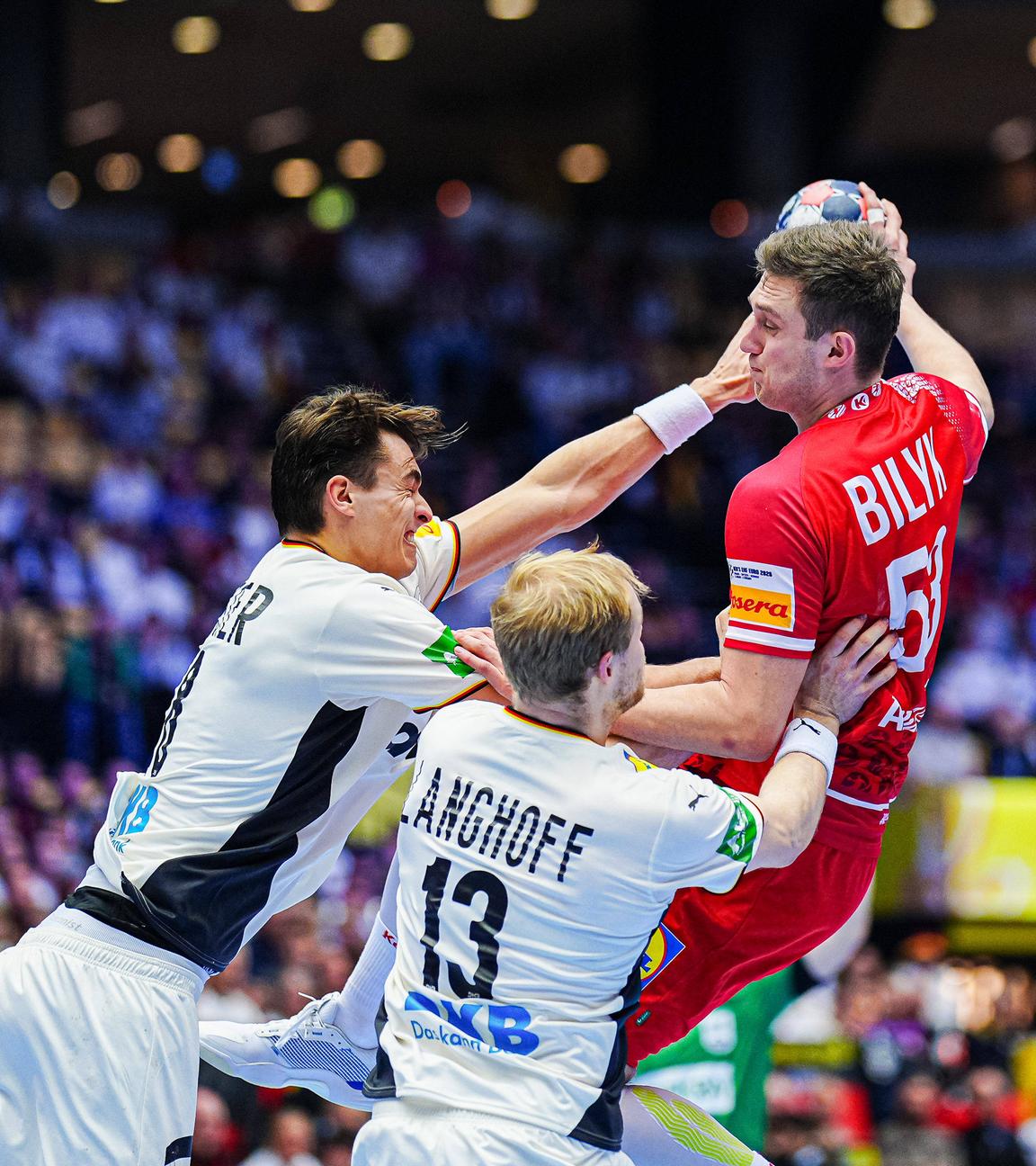 Die deutschen Handballspieler Julian Köster und Matthes Langhoff stören den österreichischen Gegenspieler Nikola Bilyk beim Wurf