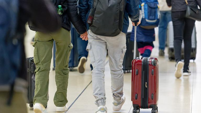 Man sieht mehrere Touristem am Flughafen