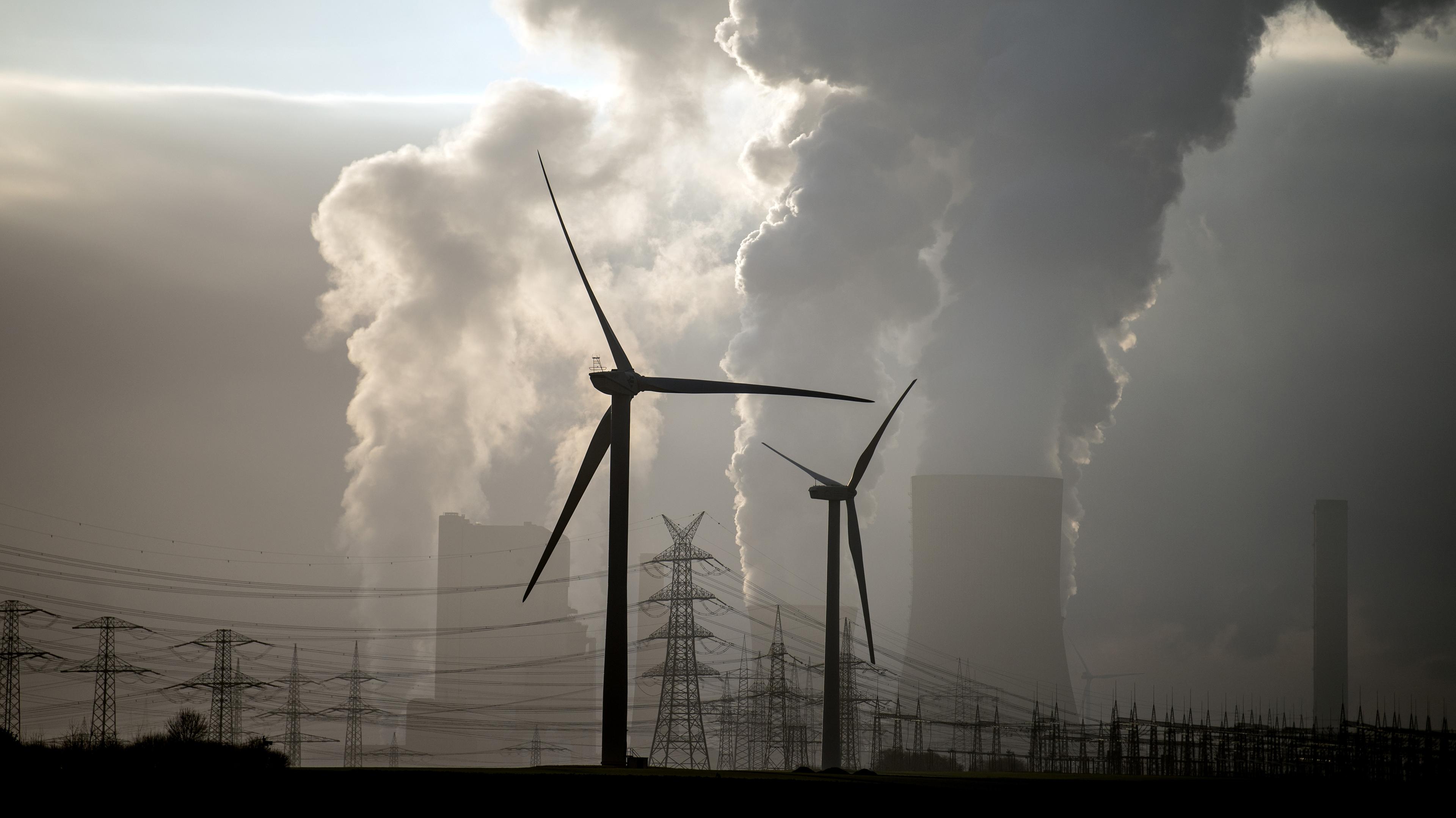 Windräder stehen vor dem Braunkohlekraftwerk Niederaußem
