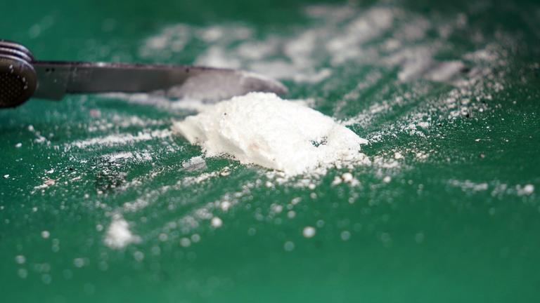 Eine geringe Menge Kokain wird mit einem Taschenmesser aufbereitet.