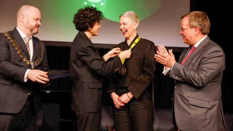 Preisträgerin Maria Kolesnikowa erhält den Internationalen Karlspreis von ihrer Schwester Tatsiana Khomich im Rathaus neben Michael Ziemons (l-r)(Oberbürgermeister der Stadt Aachen) und Armin Laschet (Mitglied des Bundestages).