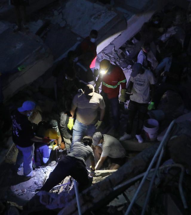 Menschen durchsuchen die Trümmer nach einem Erdbeben in Cali, Kolumbien.