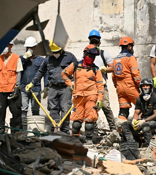 Rettungskräfte stehen zwischen den Trümmern eines zusammengestürzten Hauses in Pereira, Kolumbien.