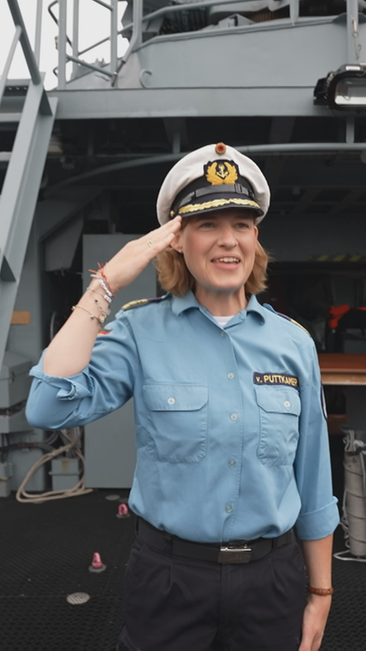 Komandeurin Inka von Puttkamer steht auf dem Marineschiff und salutiert.