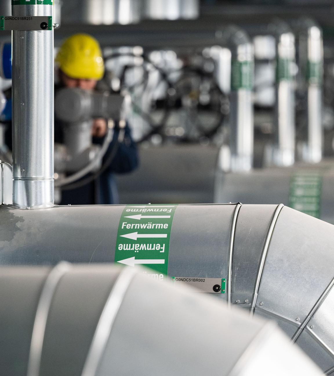 Ein Mitarbeiter des Energiekonzerns EnBW kontrolliert die Fernwärmeverteilerstation eines Heizkraftwerks