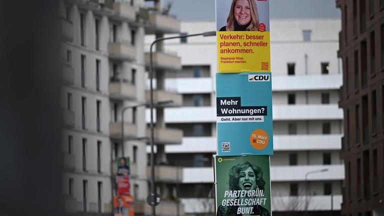 Wahlplakate der FDP, CDU und der Grünen an einer Straßenlaterne in Frankfurt.