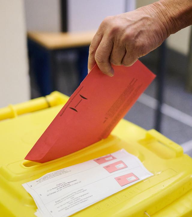 Ein Wähler wirft in einem Wahlraum im Neuen Rathaus seine Stimmzettel für die Kommunalwahl 2026 in Niedersachsen in eine Wahlurne.
