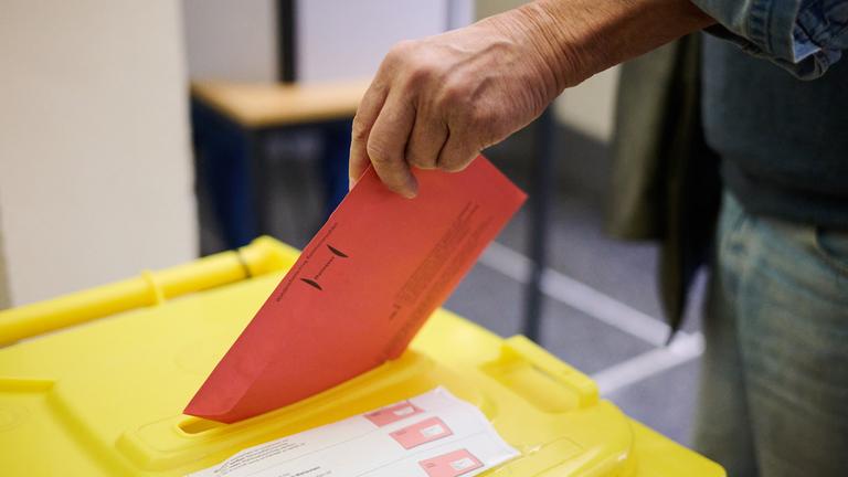 Ein Wähler wirft in einem Wahlraum im Neuen Rathaus seine Stimmzettel für die Kommunalwahl 2026 in Niedersachsen in eine Wahlurne.