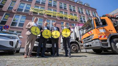 Thomas Przybylla, stellvertretender Vorsitzender des Gemeinde- und Städtebundes Rheinland-Pfalz, Daniel Köbler, Bürgermeister von Mainz, Markus Zwick, Vorsitzender des Städtetages Rheinland-Pfalz, und Nino Haase, Oberbürgermeister von Mainz, stehen zusammen und weisen mit symbolischen Uhren auf die Finanzlage der Kommunen hin.