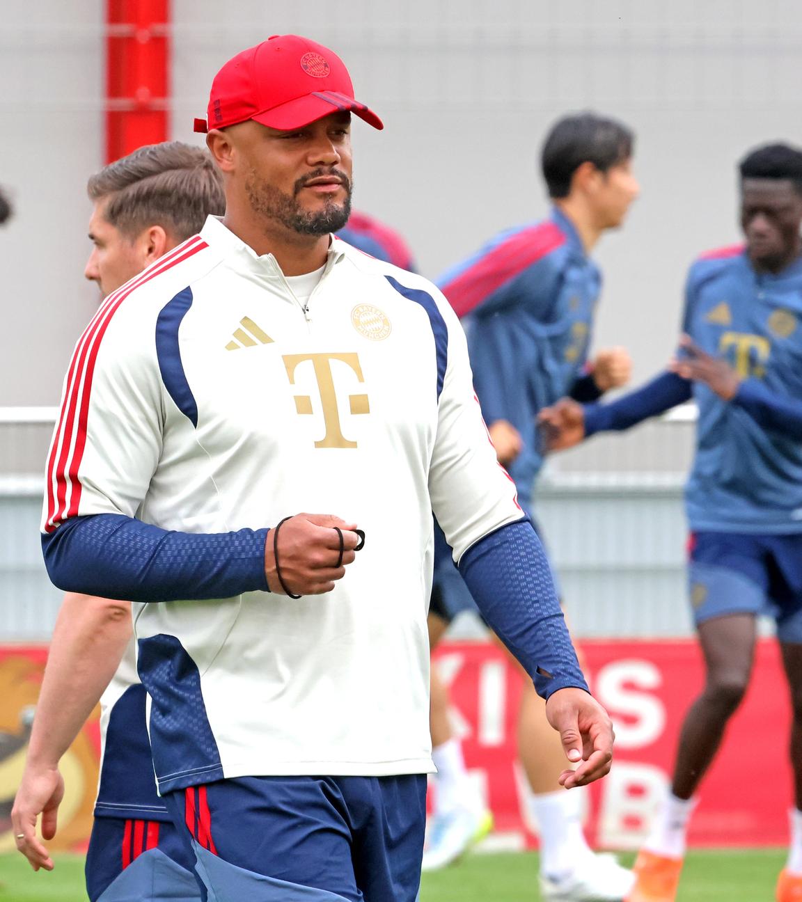 Bayern-Trainer Vincent Kompany beim Trainer, im Hintergrund Spieler.
