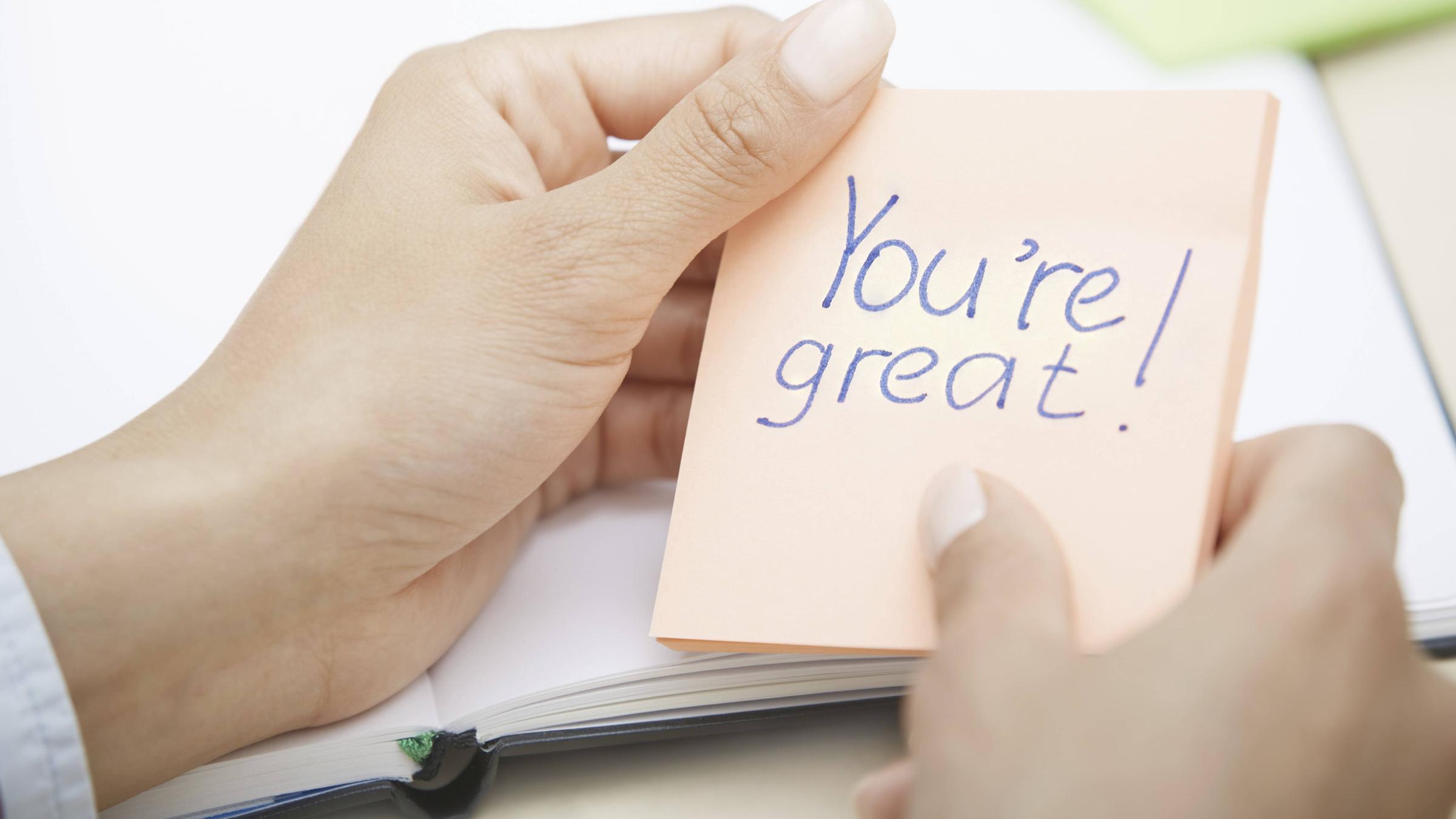 Ein Hand hölt eine Haftnotiz mit der Aufschrift "You're great".